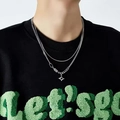 Double-layered silver necklace with sparkling star pendant worn by model on black hoodie - Heart of Darkness Necklace