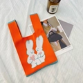 Orange knitted tote bag featuring white rabbits with pink hearts and blue trim edges - Orange Rabbit