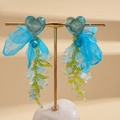 Blue chiffon heart beaded tassel earrings with fabric bow on a gold display stand - Blue Clip-on Earrings