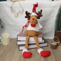 Kerst rendier pluche pop met lange benen in rode muts en trui op boeken - Rendier Hart Stijl