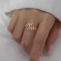 Golden olive leaf open ring with sparkling cubic zirconia worn on a finger - Gold