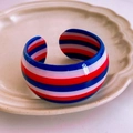 Red white and blue striped resin open bangle bracelet on a white ceramic tray - Red White Blue Striped Bangle