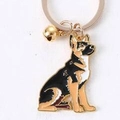 Golden German Shepherd keychain with black enamel finish and a small golden bell charm - Gold German Shepherd