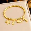 Dettaglio macro del bracciale dorato con ciondoli a tema marino su seta pregiata - Serie Oceano Stella Marina Conchiglia Balena Cavalluccio Marino (B1630)