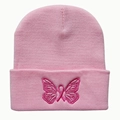 Close-up of pink butterfly and breast cancer ribbon embroidery on a knitted beanie hat - Pink
