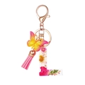 Detail of letter L resin keychain with real dried flowers, butterfly and pink tassel - Flower Pattern L