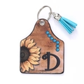 Porte-clés de style western en cuir avec tournesol, lettre D et pompon bleu - Lettre D