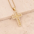 Macro shot of gold cross necklace with micro-paved cubic zirconia on stone slab - Yellow