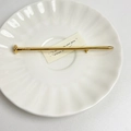 Detailed view of a gold nail-shaped brooch with a polished finish on a white plate - 41 Gold Nail (Z-1283)