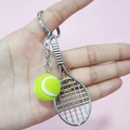 Mini tennis racket and ball keychain accessory held in hand over pink background - 2cm Ball / Green