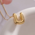 Minimalist gold-finished puffy balloon letter U pendant necklace with a polished shine - Letter U