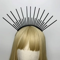 Detail of a black halo headband with radial plastic spikes on a mannequin with gold hair - Style 7