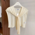 Elegant cream-white wool-blend knit shawl with tie-up design shown on a hanger - Beige