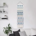 Bohemian geometric tapestry with blue and orange patterns and white fringe hanging in a living room - White 2