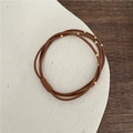 Braunes mehrlagiges elastisches Haargummi mit goldenen Perlen auf Steintablett - Dreisträngig Goldperle / Hellkaffee