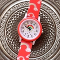 Nahaufnahme der roten Kinderuhr mit Regenbogen- und Wolkenmustern auf Silikonband - Rot