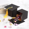 Scatola di caramelle cappello di laurea con nappa gialla su marmo bianco puro - Nero