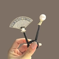 Vue détaillée d'un accessoire à cheveux en forme d'éventail avec zircons et grande perle - Forme d'Éventail Or