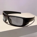 Dettaglio occhiali da ciclismo futuristici con montatura nera e lenti grigie su supporto - Montatura Nera Lenti Grigie