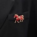 Dettaglio di una spilla a forma di cavallo in smalto rosso con strass su giacca nera - Rosso
