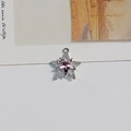 Macro shot of a silver star pendant with purple crystal and pave zircon details - Pink Star