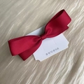 Lindo pasador de pelo con lazo rojo oscuro en tarjeta y fondo de seda beige - Rojo