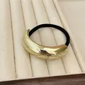 Minimalist black elastic hair tie with curved golden metallic mirror finish charm - Gold