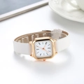 Detail shot of rectangular gold case and white leather strap of a stylish quartz watch - White