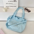 Detail der hellblauen Canvas-Tasche mit weißer Stickerei und verstellbarem Riemen - Hellblau