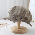 Dettaglio di un basco a quadri marrone con fiocco decorativo su supporto di legno - Quadri Cachi / M (56-58cm)