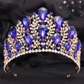 Detail of baroque gold crown featuring large blue gemstones and sparkling crystals on black - KC Gold Clear and Blue Rhinestone