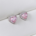 Macro view of pink heart-shaped cubic zirconia stud earrings with silver-tone halo setting - Pink