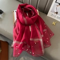 Detail of red mesh shawl featuring gold silk stripes and delicate white pearl beadwork - Burgundy
