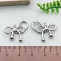 Silver bow tie pendant charm for jewelry making shown with size measuring ruler - Twisted Bowknot - Silver (21405)