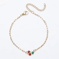 Detail van 18K vergulde paperclip armband met kersenhanger en handige karabijnsluiting - Armband / Goud+Rood