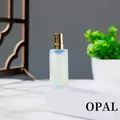 Opal natural stone perfume bottle with gold spray nozzle on a white pedestal display - Opal