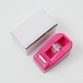 Roze plastic tape dispenser met metalen snijmes en witte verpakkingsdoos - Rozerood
