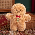 Gingerbread man plush pillow with red bowtie on patterned carpet for Christmas decor - Standing Biscuit Man