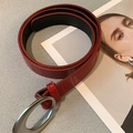 Detail shot of red crocodile texture faux leather belt with silver oval buckle buckle - Red