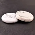 Polished white howlite crystal disc 40mm with natural grey veins on leather background - White Turquoise