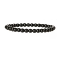 Vue macro de perles de pierre noire polie de 6mm sur un bracelet élastique - Bracelet en pierre noire brillante