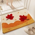Absorbent non-slip bathroom mat with tufted maple leaf design in warm orange and beige - Falling Maple Leaves