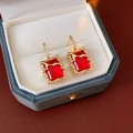 Dettaglio orecchini dorati con pietre rosse e piccoli diamanti in scatola di velluto - Perno per orecchini in argento-Oro-Rosso