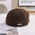 Detail of a brown cotton miki hat featuring a raw frayed edge and a silver metal tag - 55-58cm / Metal Label Style / Coffee