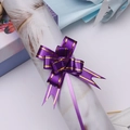 Close-up of a purple gift ribbon bow with gold edges tied on a white decorative roll - Purple Gold Edge