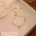 Dettaglio del bracciale Evil Eye regolabile dorato con ciondolo lettera K su vassoio - Lettera K