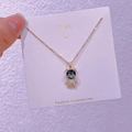 Dettaglio collana orso dorata con testa in resina blu e corpo di cristallo su carta bianca - Orso Cielo Stellato (XK0031)
