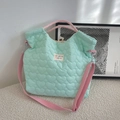 Close-up of heart-quilted texture on mint green tote bag with woven stripe handles - Heart Green