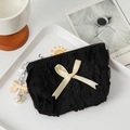 Detail of black polka dot pouch with ruffle edges, beige bow and pearl pendant charm - Black