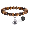 Close-up of tiger eye stone bracelet with heart projection charm on white background - Tiger's Eye